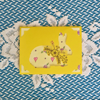 Yellow card with a rabbit design on a textured blue and white background