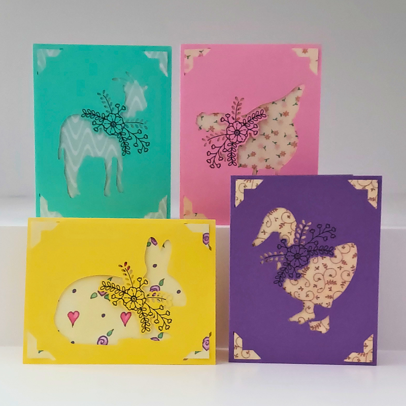 Four colorful greeting cards with animal illustrations on a white background