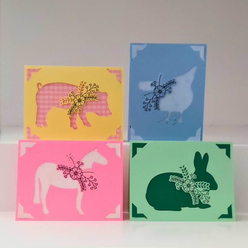 Four colorful greeting cards with animal illustrations on a white background