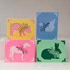 Four colorful greeting cards with animal illustrations on a white background