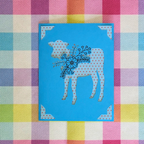 Card with a polka dot cow design on a colorful checkered background