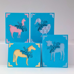 Four blue greeting cards with animal illustrations on a white background