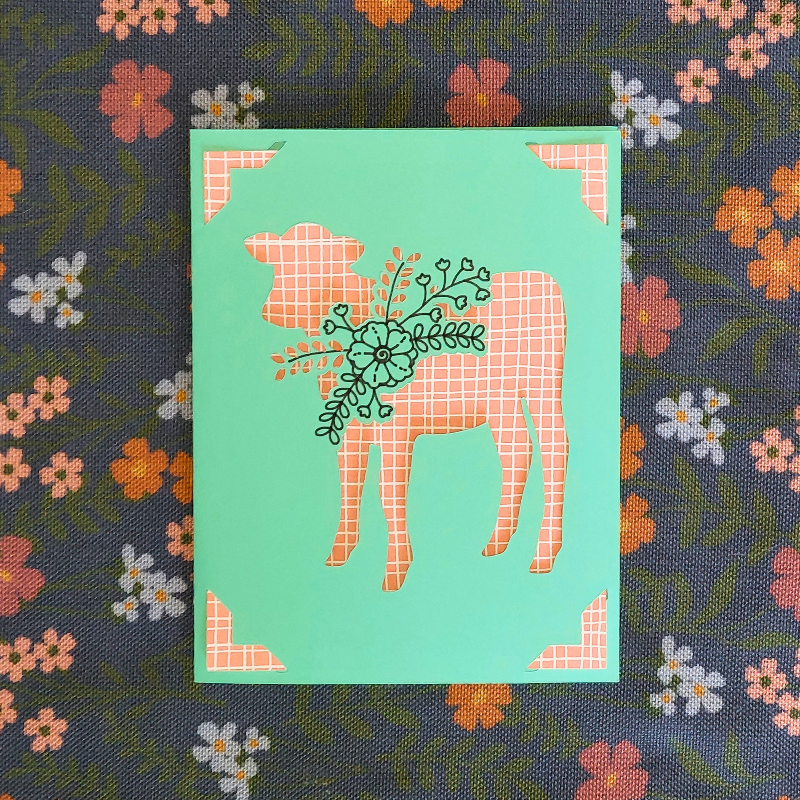 Card with a cow illustration on a floral background