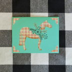 Card with a stylized horse design on a checkered fabric background