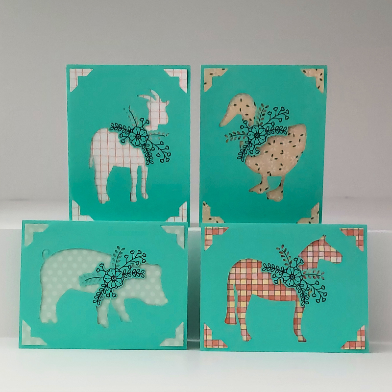 Four turquoise cards with animal illustrations on a white background