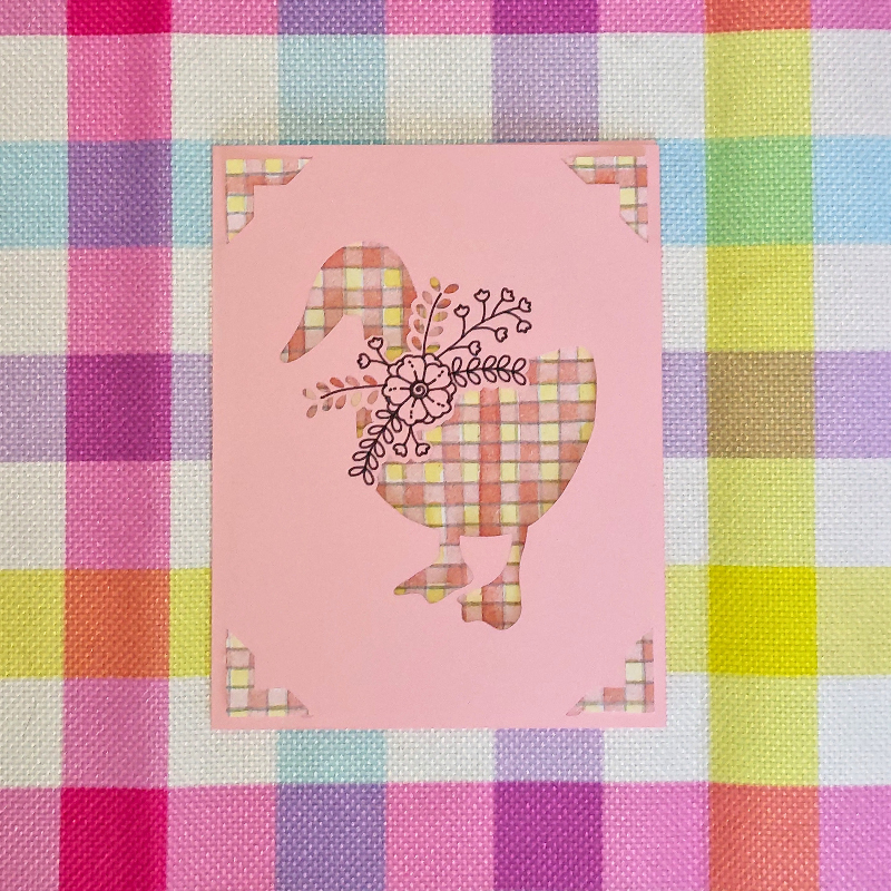 Decorative card with a stylized goose design on a colorful checkered background
