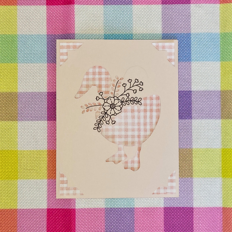 Card with a goose design on a colorful checkered fabric background