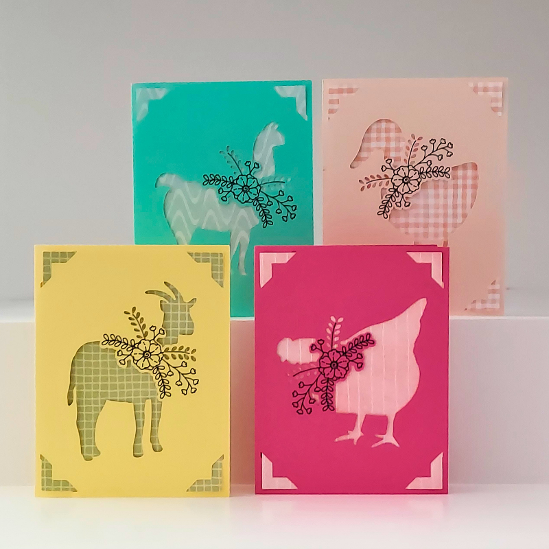 Four colorful greeting cards with animal silhouettes on a white background