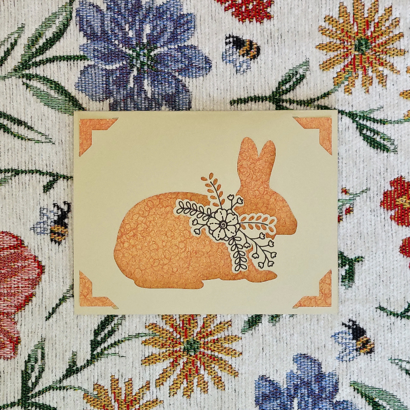 Card with a rabbit design on a floral patterned background