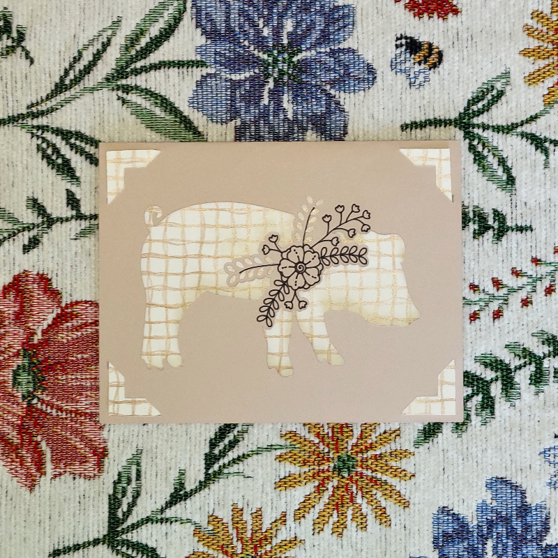 Card with a pig design on a floral background