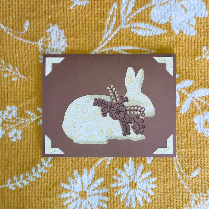 Card with floral rabbit design on a yellow floral fabric background