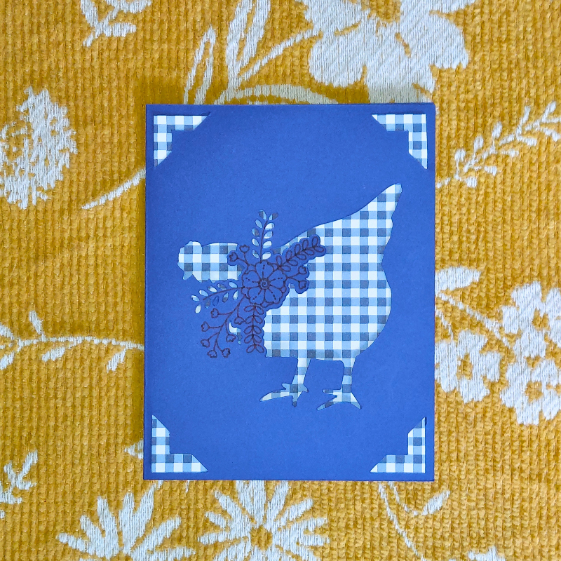 Blue card with a floral design on a yellow fabric background