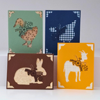 Four greeting cards with animal illustrations on a white background