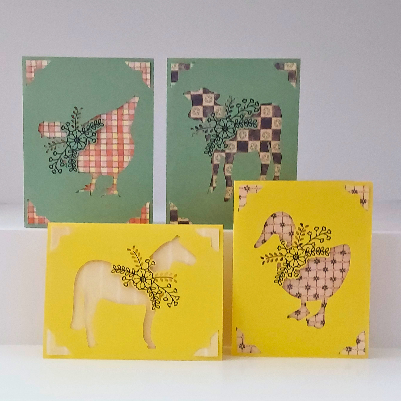 Four greeting cards with animal illustrations on a white background