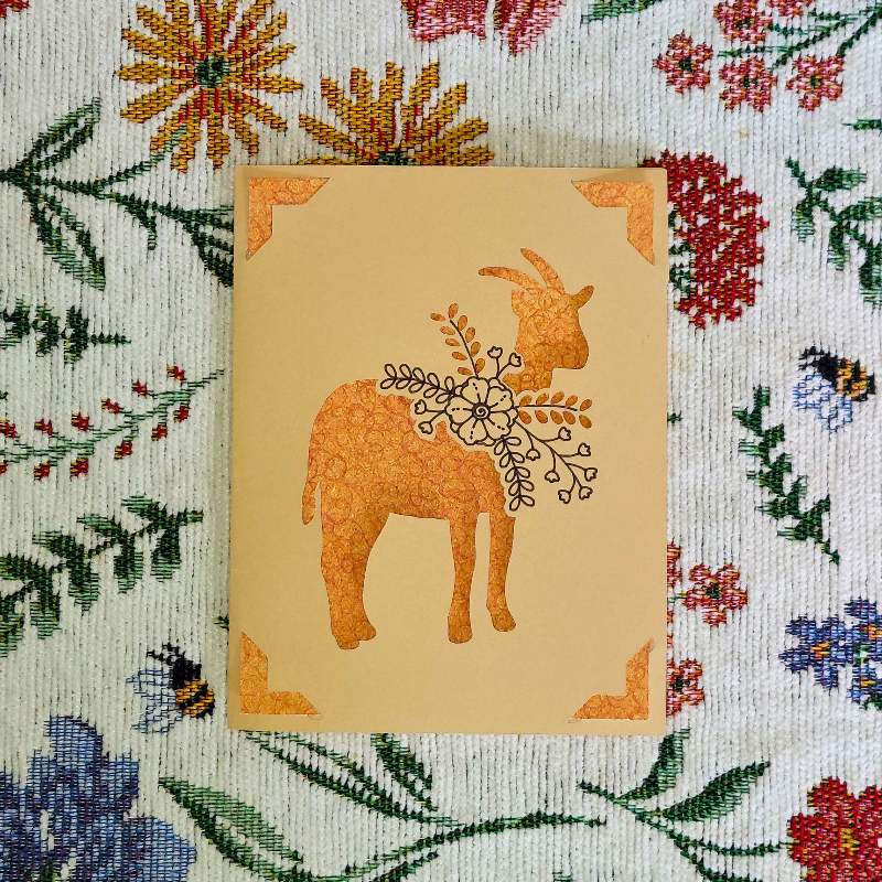 Card with a goat illustration on a floral patterned background