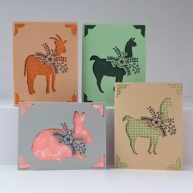 Four greeting cards with animal illustrations on a white background