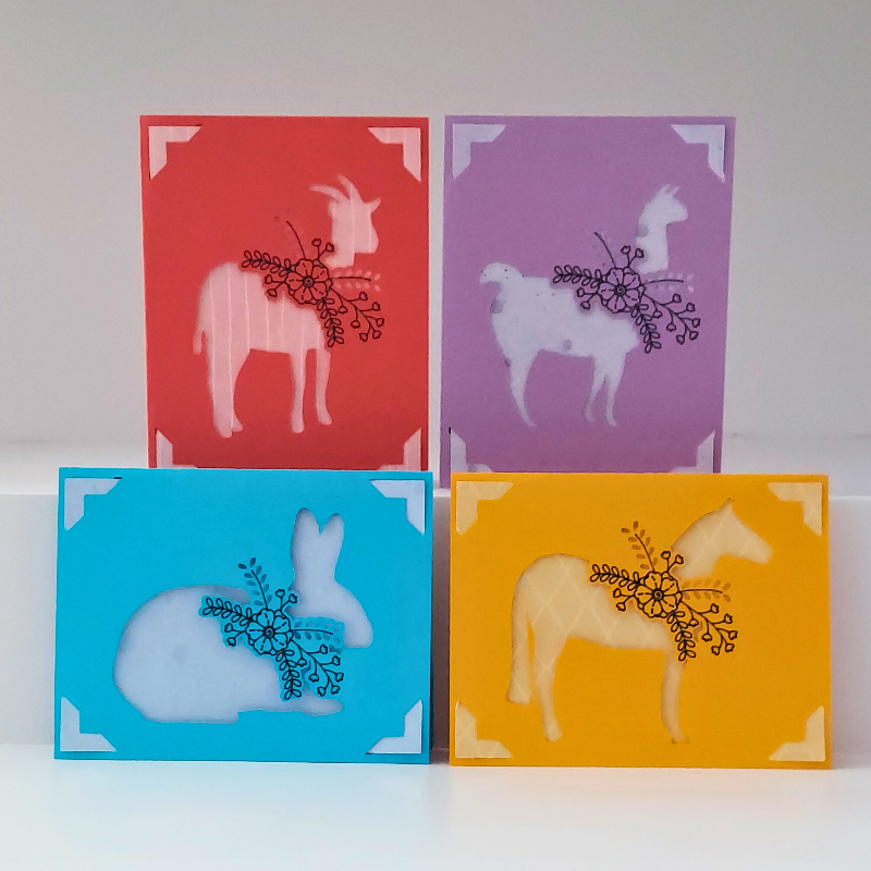 Four colorful cards with animal silhouettes on a white background