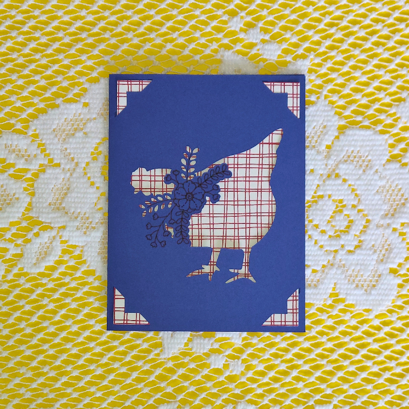 Card with a blue silhouette of a chicken with flowers on a yellow and white patterned background