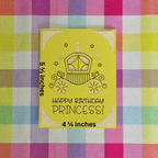 Yellow birthday card with princess carriage design on a checkered fabric background