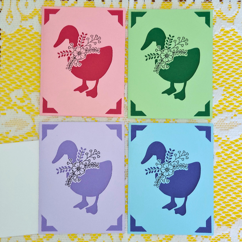 Four colorful cards with goose illustrations on a patterned background