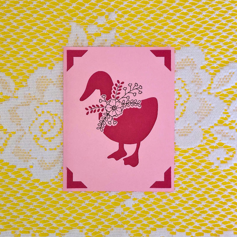 Pink card with pink goose design on a yellow and white patterned background