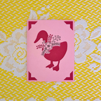 Pink card with pink goose design on a yellow and white patterned background