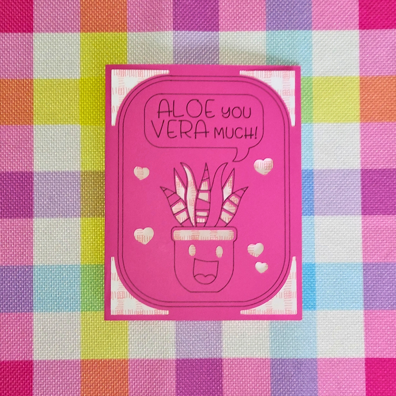 Pink card with aloe vera design and text on a colorful checkered background