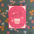 Pink birthday card with cactus illustration on a floral background
