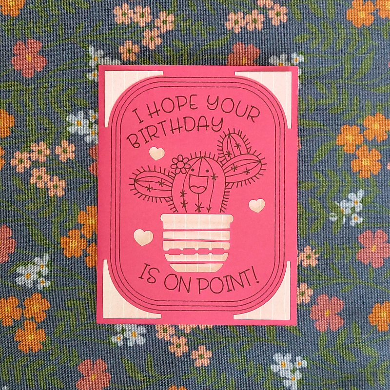 Pink birthday card with cactus illustration on a floral background