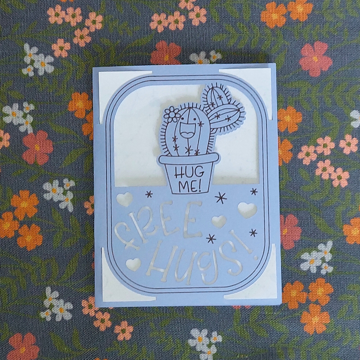 Card with a cactus illustration and 'Free Hugs' text on a floral background