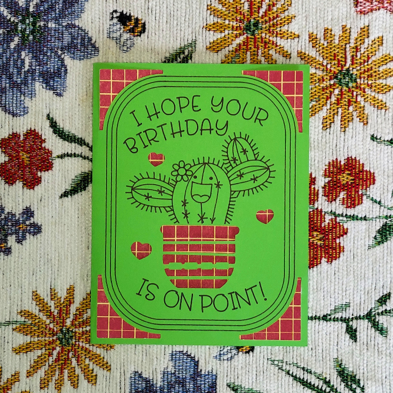 Green birthday card with cactus illustration on a floral background