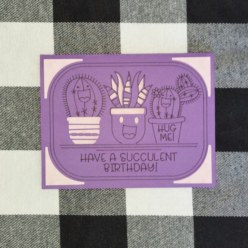 Purple card with succulent illustrations and text on a checkered fabric background