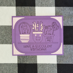 Purple card with succulent illustrations and text on a checkered fabric background