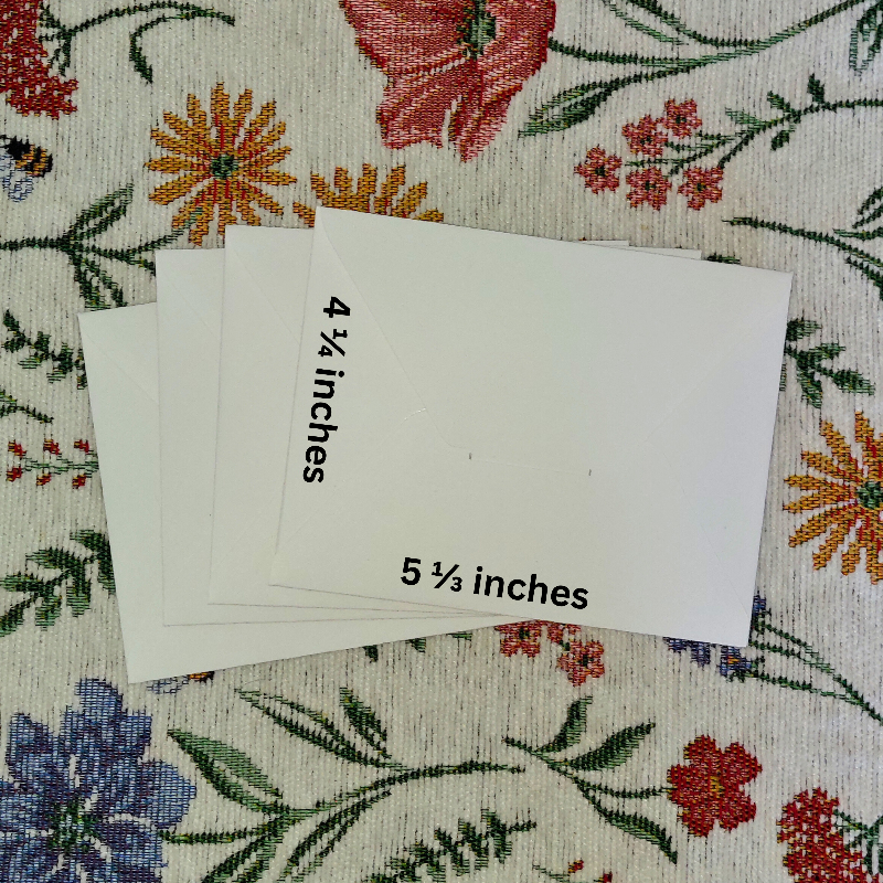 Four envelopes with measurements on a floral fabric background